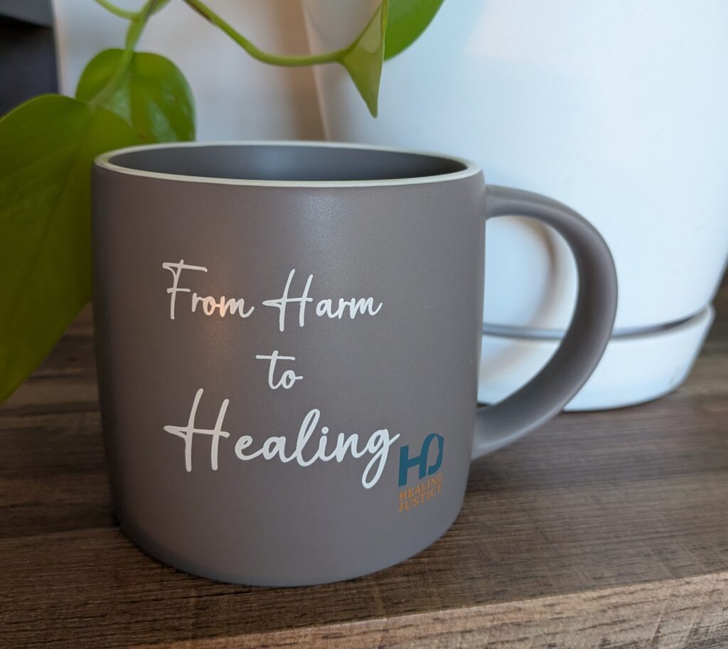 Grey mug "From harm to Healing" with Healing Justice's logo